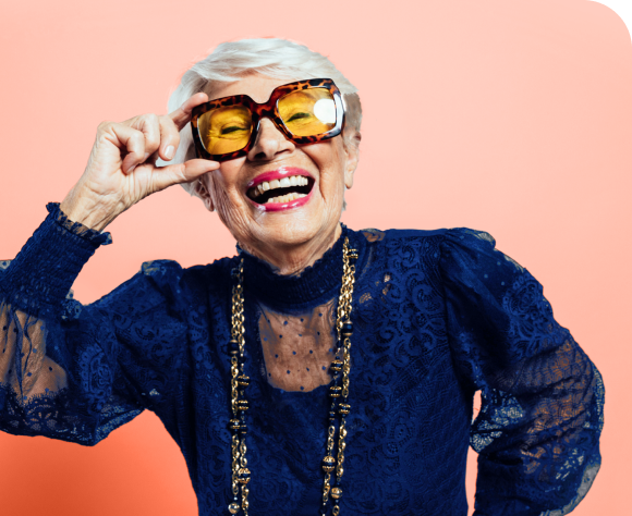 a person smiling with a blue dress and yellow sunglasses