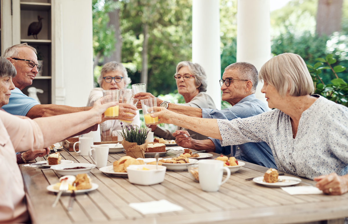 a group of people sitting at a table with food and drinks