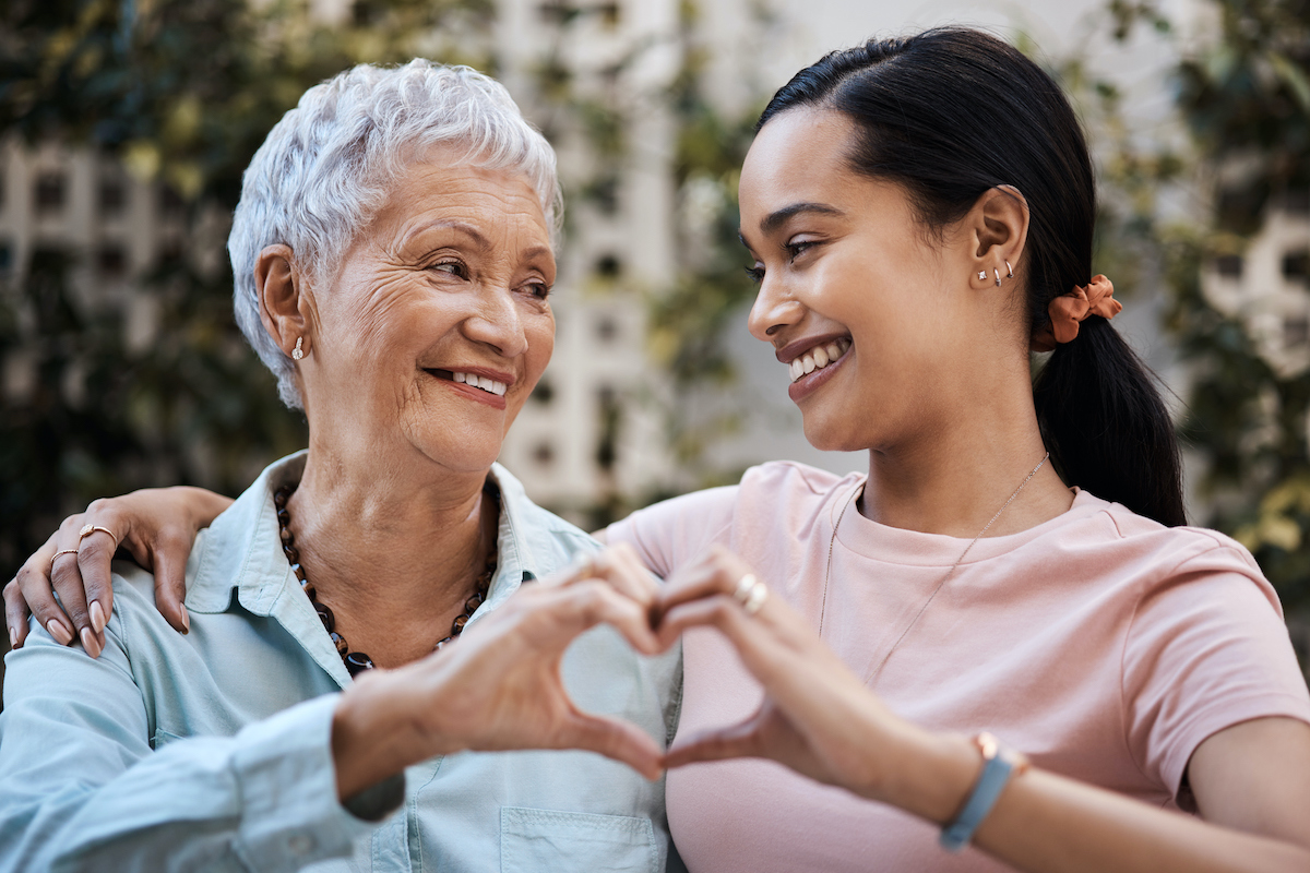 a person and a young person making a heart with their hands