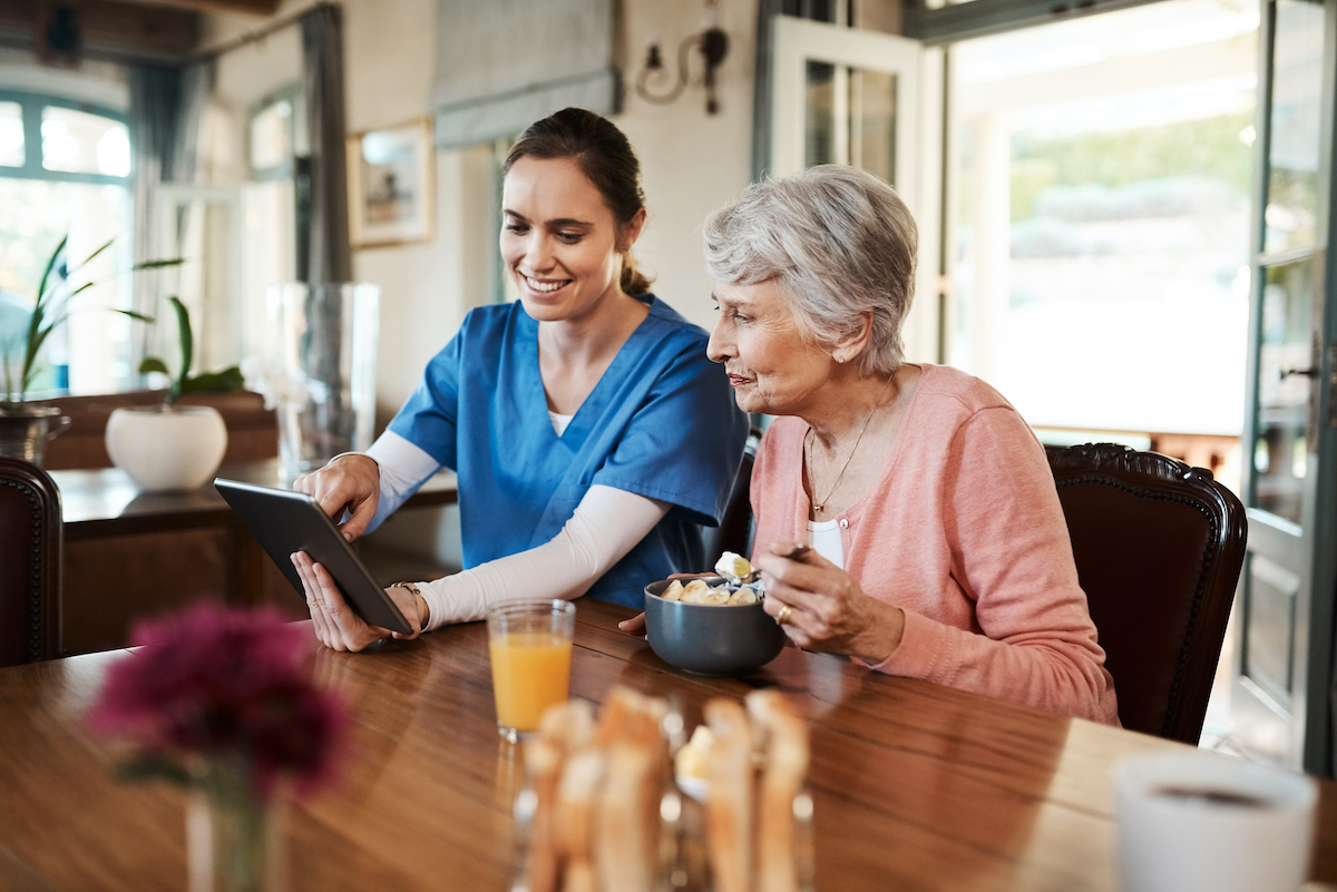 a person and a nurse looking at a tablet