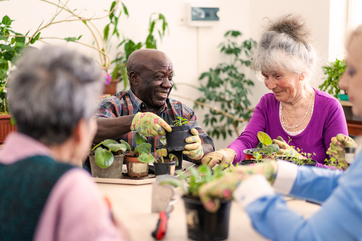 a group of people sitting around a table with plants