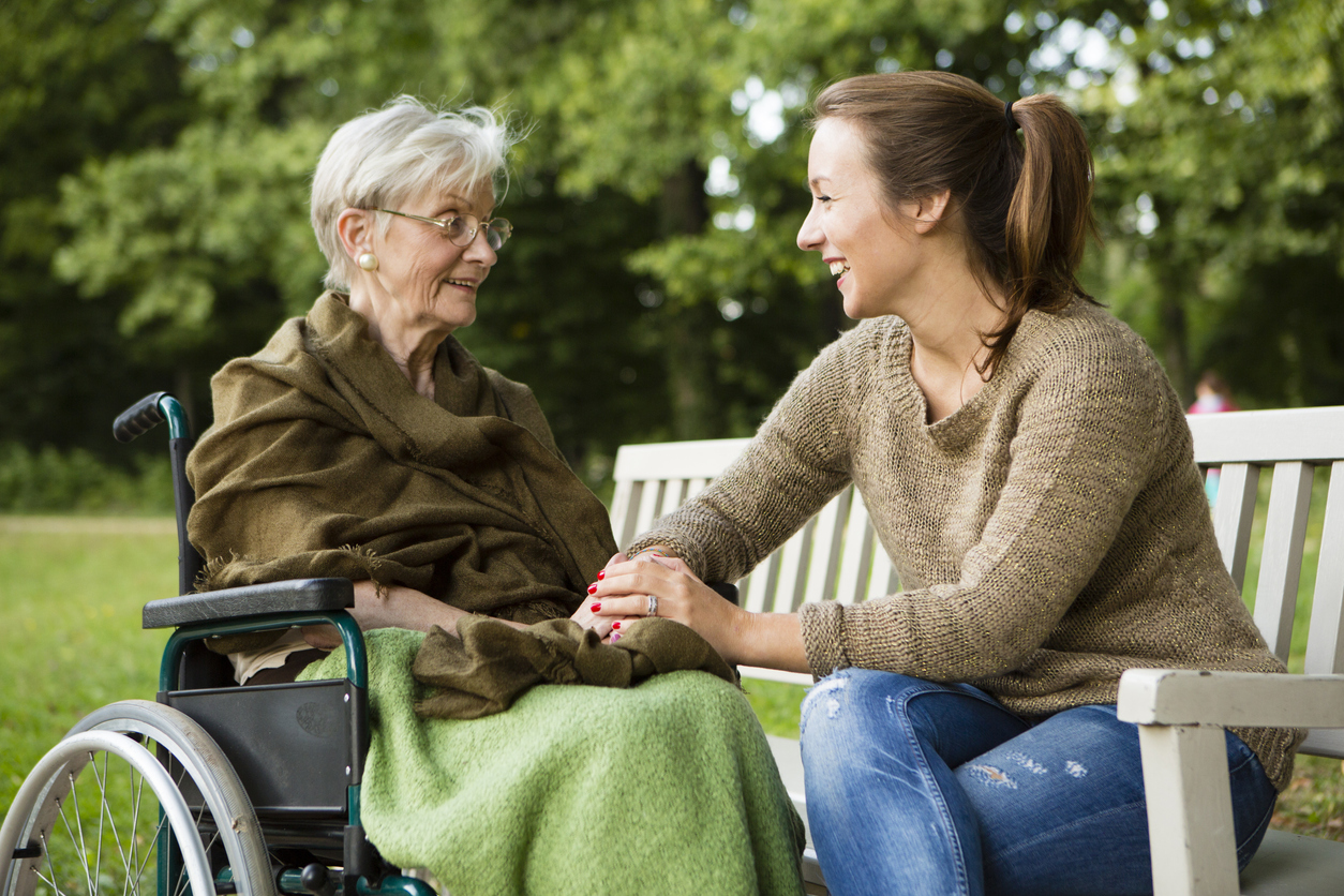 a person sitting on a bench with a person in a wheelchair