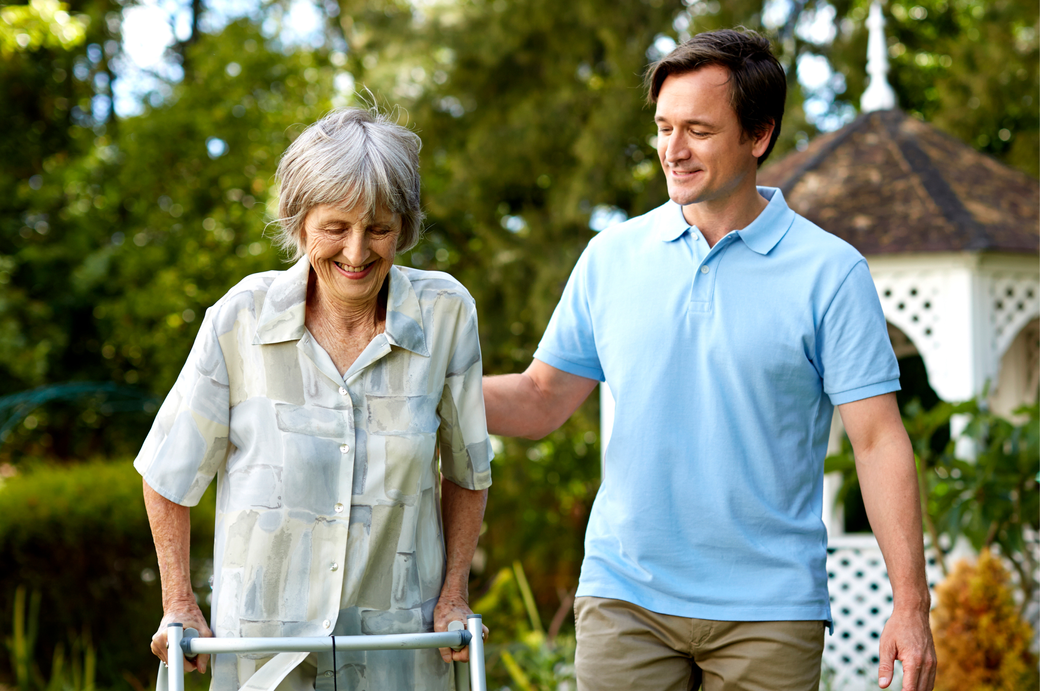 a person helping an old person with a walker